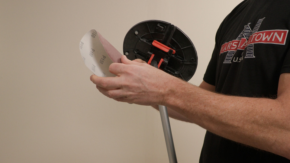 man creasing the sandpaper to prepare for corner sanding
